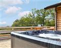 Relax in your Hot Tub with a glass of wine at Cwm Yr Hendy Lodges - Hillside View; Powys